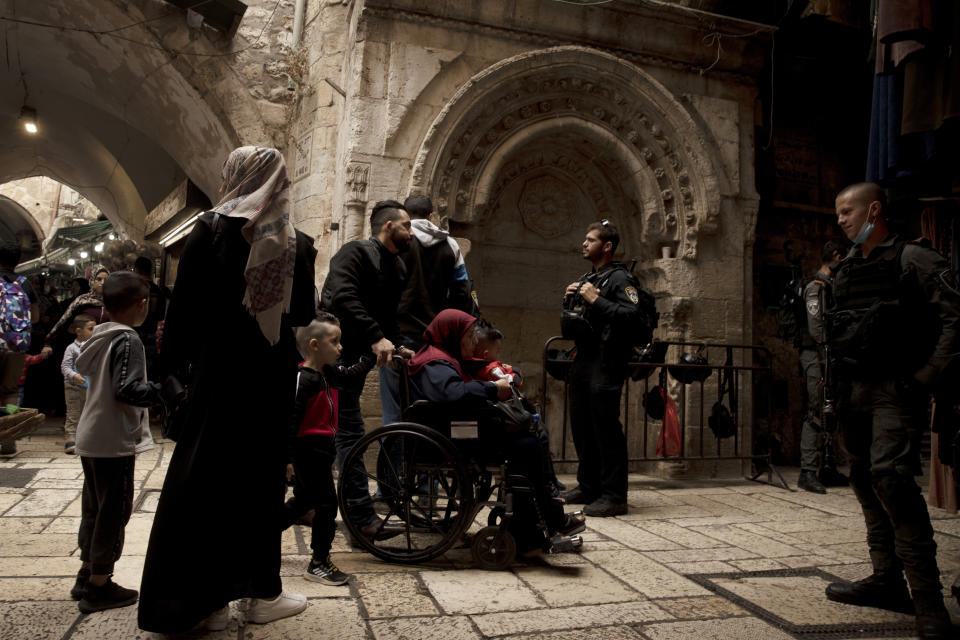 A Palestinian family approaches an Israeli police checkpoint in the Old City of Jerusalem on their way to prayers at the Al Aqsa Mosque compound marking Moulid al-Nabi, the birthday of the Muslim Prophet Muhammad, Tuesday, Oct. 19, 2021. (AP Photo/Maya Alleruzzo)