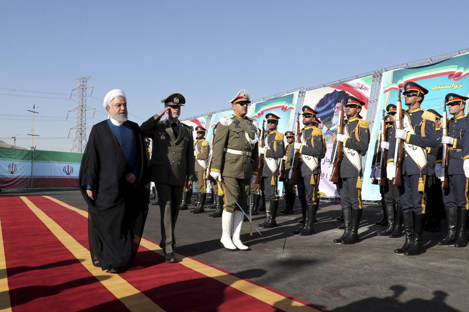 In this photo released by the official website of the office of the Iranian Presidency, President Hassan Rouhani, left, reviews an honor guard as he is accompanied by his Defense Minister Gen. Amir Hatami during a ceremony to unveil Iran-made Bavar-373 air-defense missile system, Iran, Thursday, Aug. 22, 2019. Iran says the Bavar-373 is a long-range surface-to-air missile system able to recognize up to 100 targets at a same time and confront them with six different weapons. (Iranian Presidency Office via AP)