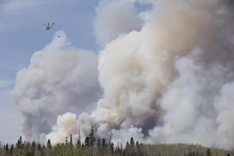 A helicopter battles a wildfire in Fort McMurray Alta, on Wednesday May 4, 2016. THE CANADIAN PRESS/Jason Franson