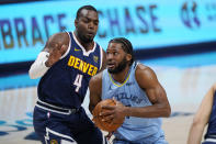 Memphis Grizzlies forward Justise Winslow, front, drives to the basket past Denver Nuggets forward Paul Millsap in the first half of an NBA basketball game Monday, April 19, 2021, in Denver. (AP Photo/David Zalubowski)