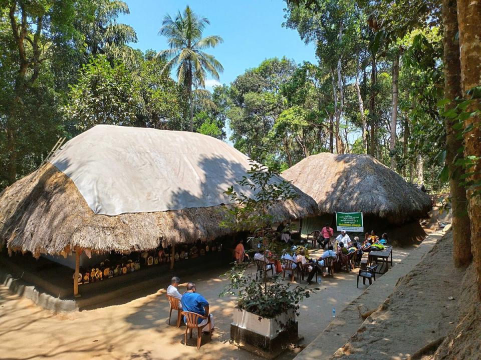 Padma Shri award-winner and tribal leader Cheruvayal Raman (in white) surrounded by his supporters seen at his house in Mananthavady in Wayanad. Dozens of trophies won by him are seen placed in the shade of his mud house (Arpan Rai/ The Independent)