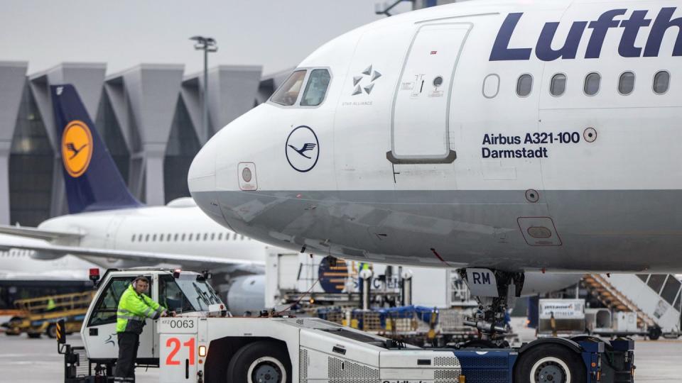 Ein Diesel-Schlepper zieht einen Airbus der Lufthansa von seiner Position am Fluggaststeig in Frankfurt.