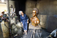 Sculptor Dana King examines her bust of Black Panther Party co-founder Huey Newton at Artworks Foundry on Tuesday, Aug. 10, 2021, in Berkeley, Calif. The bust is scheduled to be unveiled in Oakland on Sunday, Oct. 24, the first permanent public art piece honoring the party in the city of its founding. (AP Photo/Noah Berger)