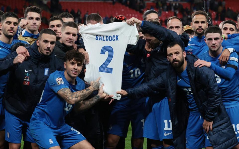 The Greece squad held up a shirt with George Baldock’s name on after their Wembley win (Action Images via Reuters)