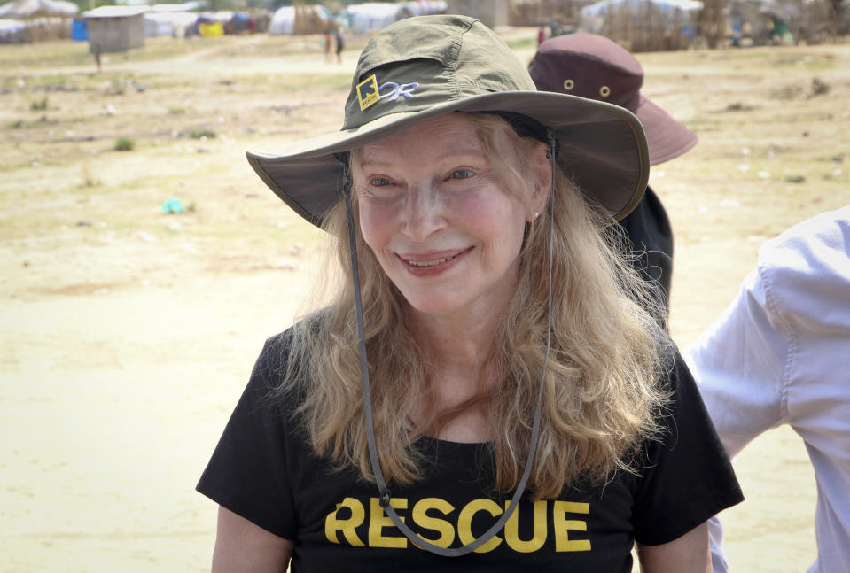 In this photo taken Tuesday, April 2, 2019, human rights activist Mia Farrow smiles while interacting with women and children in an internally displaced person's camp in the capital Juba, South Sudan. Human rights activist Mia Farrow spoke to The Associated Press as she visited South Sudan again in her new role as envoy for the International Rescue Committee, helping the aid group to promote a global initiative to change the way humanitarian organizations approach malnutrition. (AP Photo/Sam Mednick)