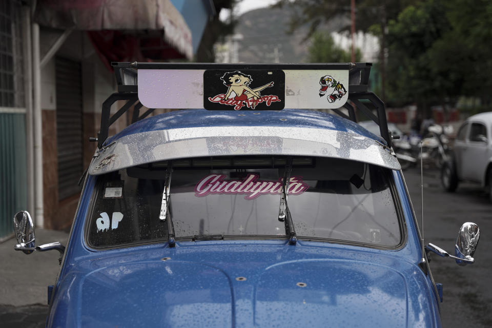 The bright blue Volkswagen Beetle owned by taxi driver Claudio Garcia that he named "Gualupita" after his wife, sits parked in the Cuautepec neighborhood of Mexico City, Friday, June 21, 2024. While some of the older Beetles wobble along, paint long faded after years of wear and tear, other drivers like Garcia dress their cars up, keeping them in top shape. (AP Photo/Aurea Del Rosario)