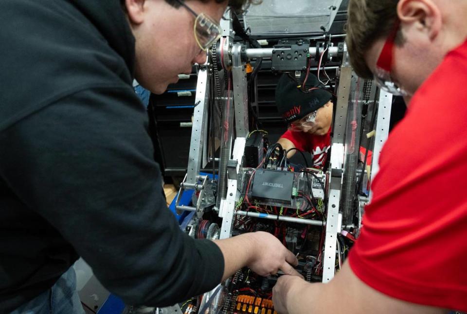 Pleasant Grove High School EagleForce team members Cameron Fong, Lucian Mayers-Viseroi and Jason Keyes adjust the robot before the next round of competition during the FIRST Robotics Competition at their school in Elk Grove on Friday.