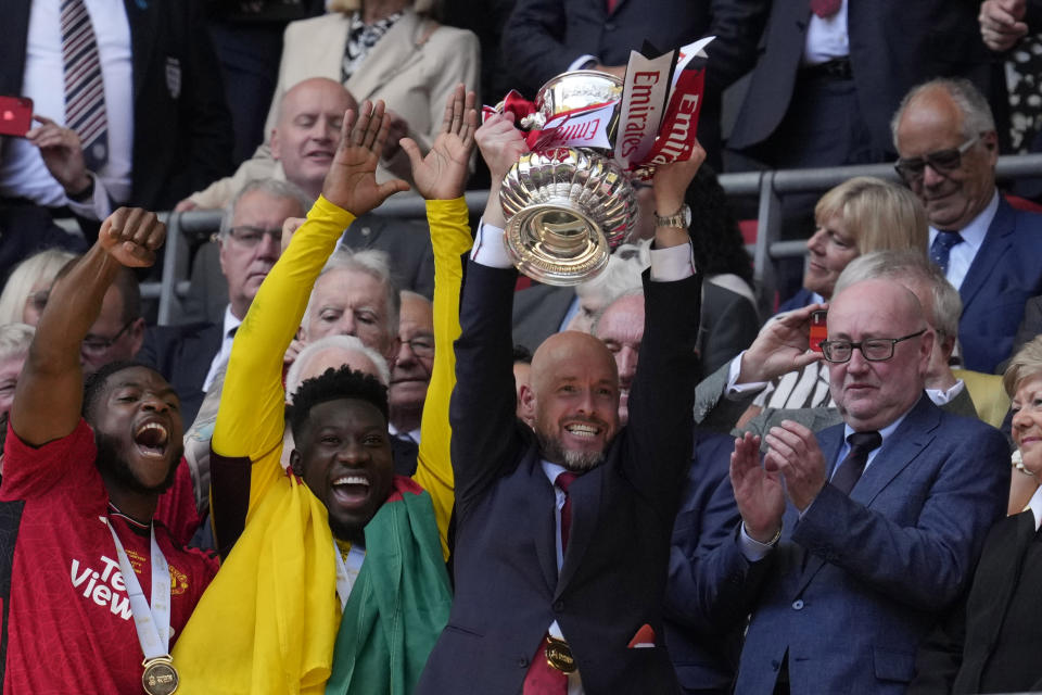 Manchester United's head coach Erik ten Hag, right, raises the trophy after his team won the English FA Cup final soccer match between Manchester City and Manchester United at Wembley Stadium in London, Saturday, May 25, 2024. Manchester United won 2-1. (AP Photo/Kin Cheung)