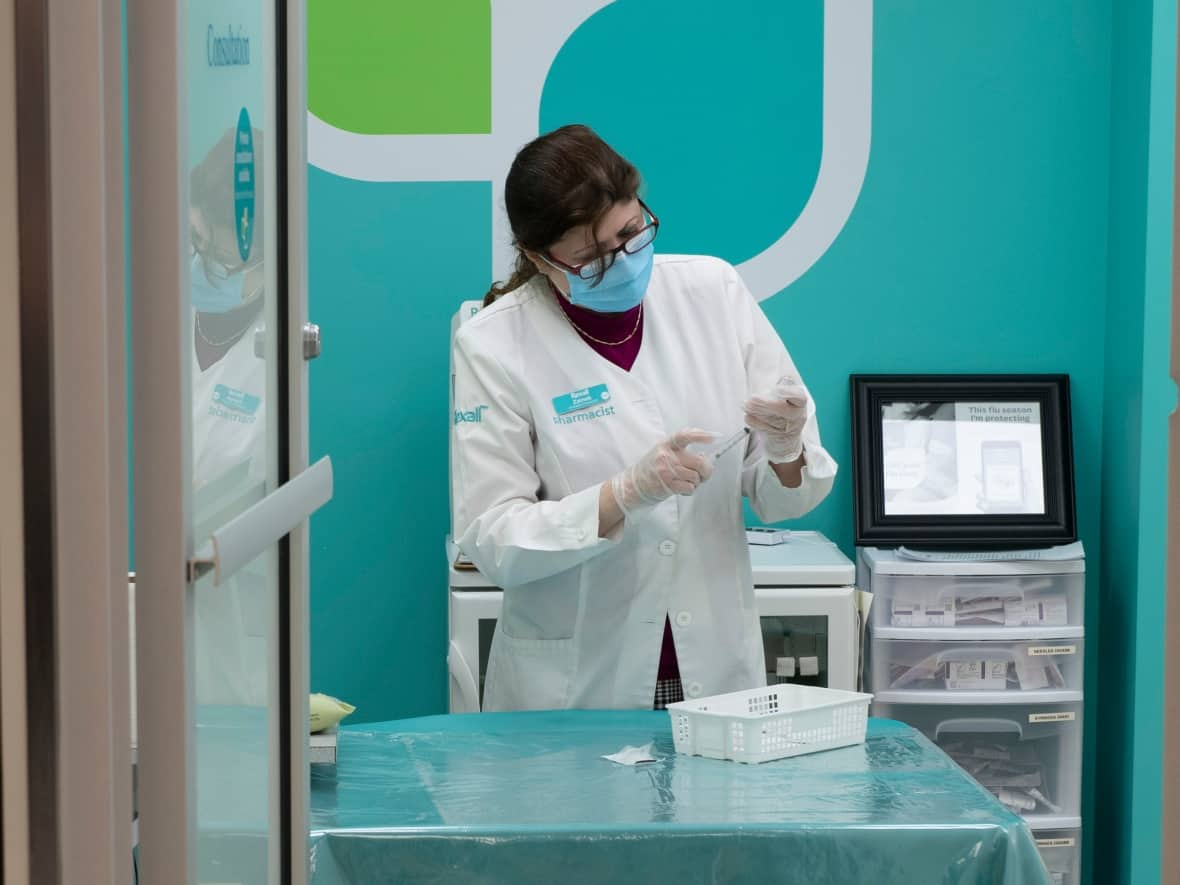 Pharmacist Zaineb Hassan prepares COVID-19 vaccines to administer at a pharmacy in Ottawa in April 2021. (Adrian Wyld/The Canadian Press - image credit)