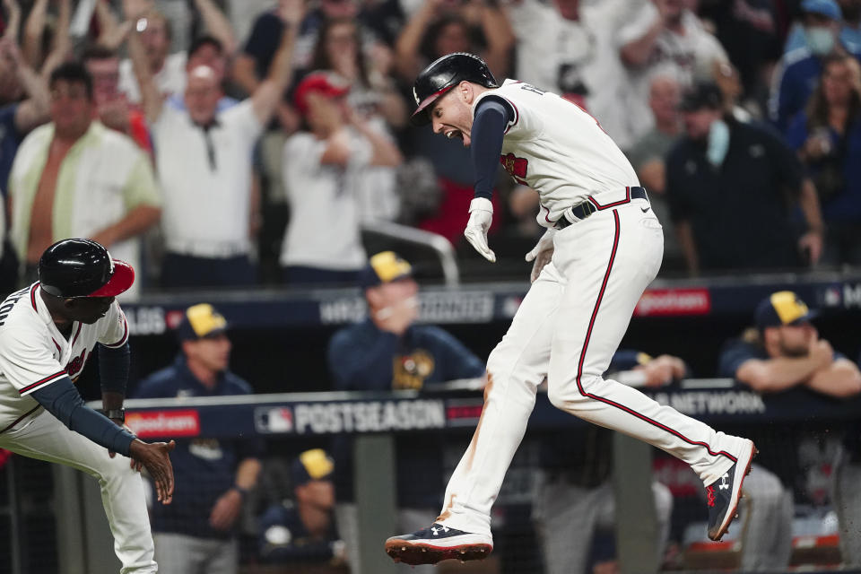 Atlanta Braves' Freddie Freeman, right, celebrates his solo homerun during the eighth inning of Game 4 of a baseball National League Division Series against the Milwaukee Brewers, Tuesday, Oct. 12, 2021, in Atlanta. (AP Photo/John Bazemore)