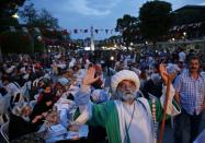 <p>A man in Ottoman attire poses for pictures as people break their fast in the historic Sultanahmet district of Istanbul, Turkey, May 27, 2017. (AP Photo/Lefteris Pitarakis) </p>