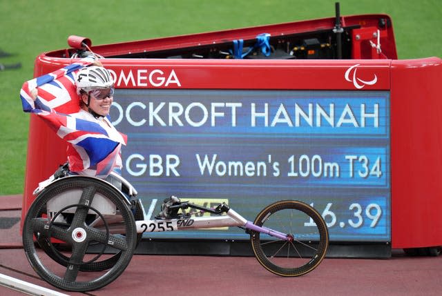 Great Britain’s Hannah Cockroft poses with the score board showing her new world record time