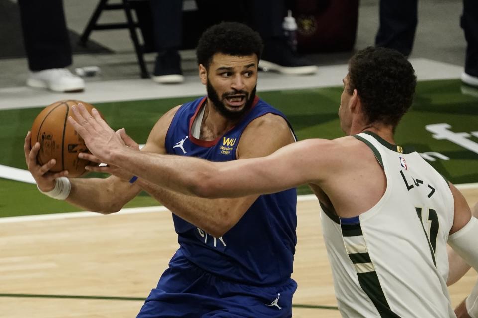 Denver Nuggets' Jamal Murray tries to get past Milwaukee Bucks' Brook Lopez during the first half of an NBA basketball game Tuesday, March 2, 2021, in Milwaukee. (AP Photo/Morry Gash)