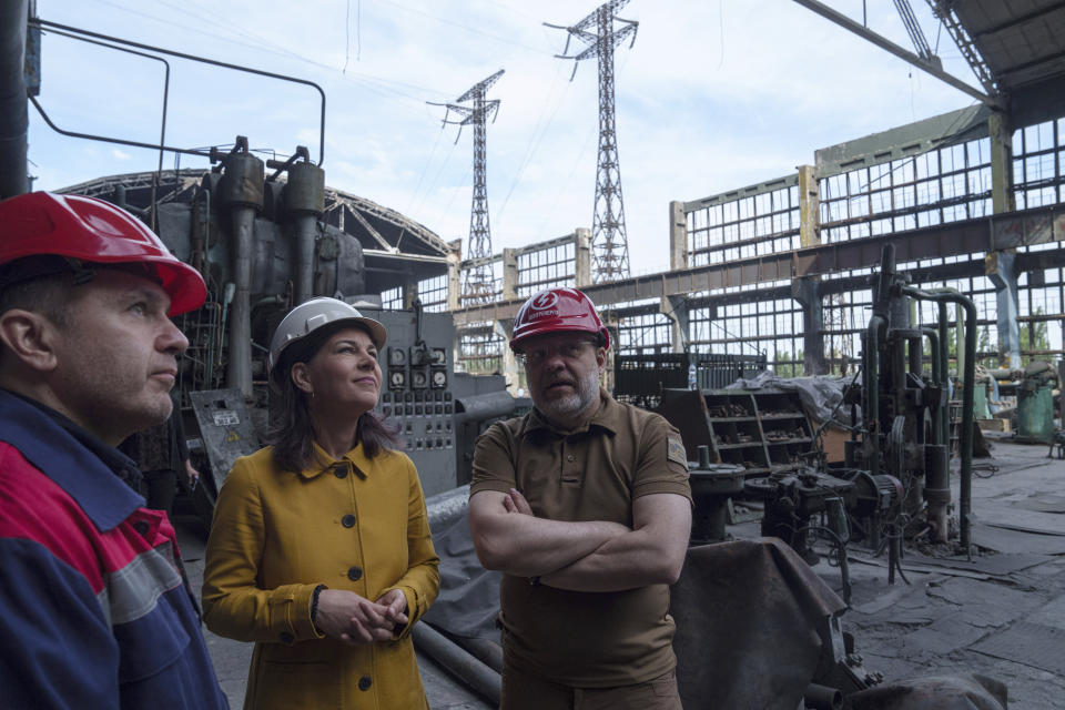 German Foreign Minister Annalena Baerbock, second from left, speaks to Ukrainian Energy Minister Herman Halushchenko during official visit to a thermal power plant which was destroyed by a Russian rocket attack in Ukraine, Tuesday, May 21, 2024. (AP Photo/Evgeniy Maloletka)