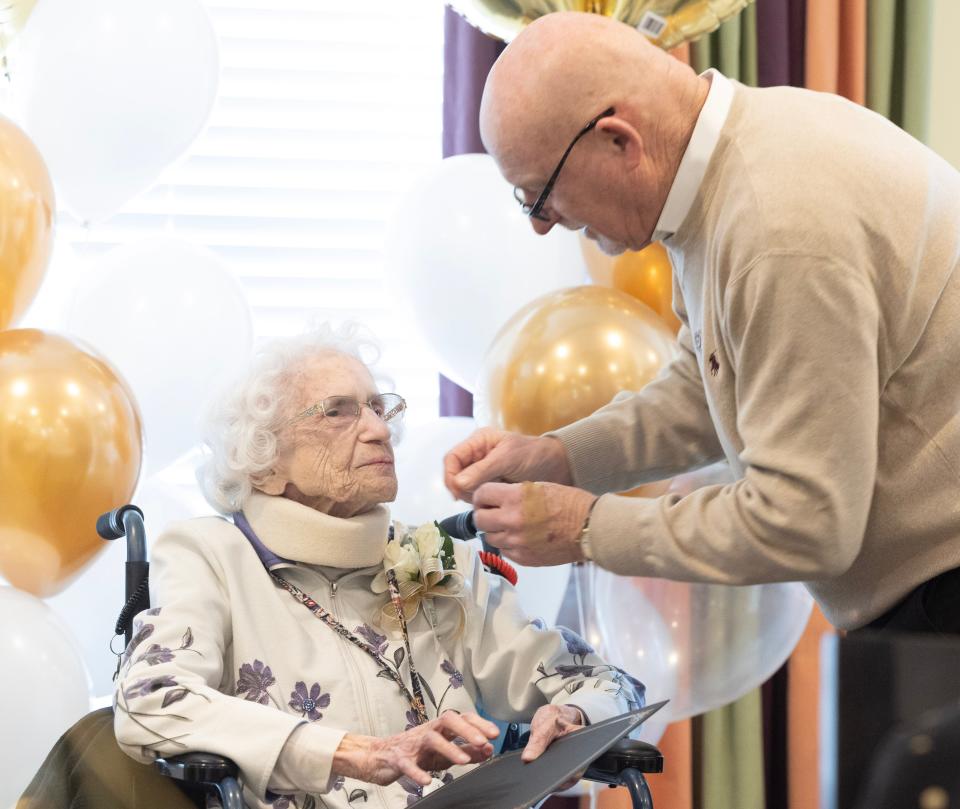 North Canton Mayor Stephan Wilder pins a veterans pin from the Stark County Veterans Commission on Helen Blocker for her service in WWII.