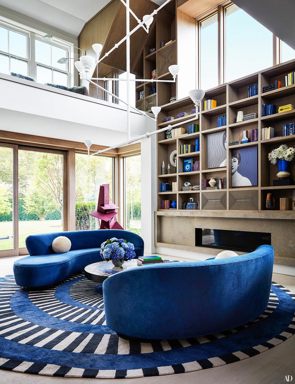 A chandelier by Stephen Antonson hangs in the double-height library. Holland & Sherry cotton velvet on Vladimir Kagan sofas; bespoke rug by Kelly Behun for the Rug Company.