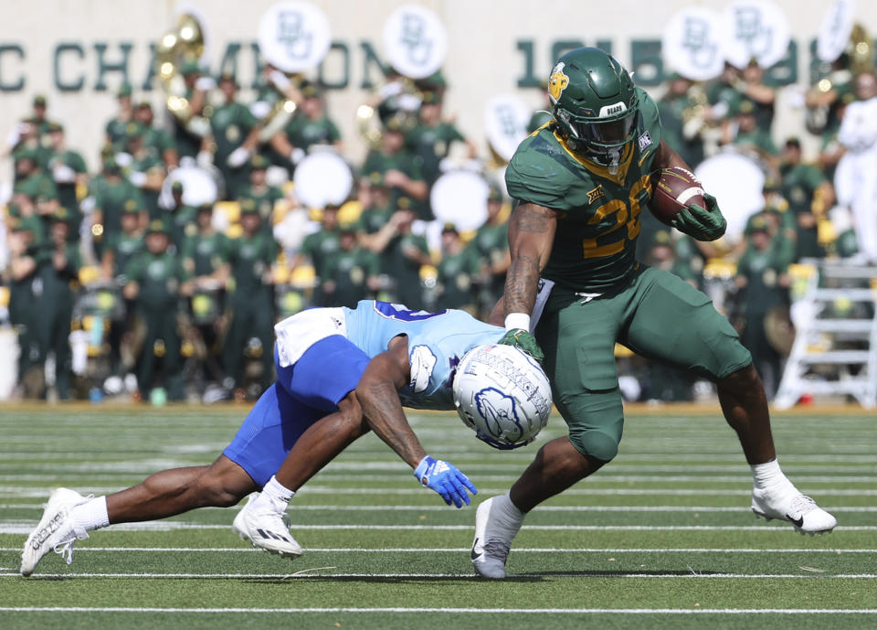 Baylor running back Richard Reese stiff arms Kansas cornerback Kalon Gervin in the second half of an NCAA college football game, Saturday, Oct. 22, 2022, in Waco, Texas. (AP Photo/Jerry Larson)