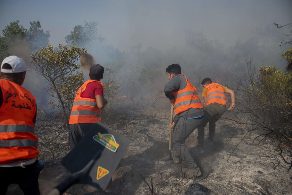 Workers try to put out a forest blaze in Laarache, northern Morocco, Friday, July 15, 2022. Fires fanned by strong winds and extreme termperatures have spread across hundred of hectares since Thursday evening. (AP Photo)