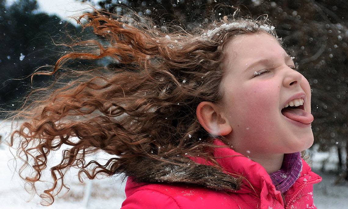 Sarah Beth Syfrett. 9, tries to catch snowflakes with her tongue as she runs home after sledding with her sister and mom in the community park at the Parkwood subdivision in south Durham as snow falls Tuesday, Feb. 24, 2015.
