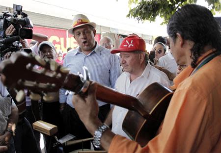 Luis Guillermo Solis (L), presidential candidate of the Citizens' Action Party (PAC), sings beside a group of street musicians during a walk in San Jose April 4, 2014. Costa Rica's center-left presidential candidate Solis is expected to cruise to victory in the run-off election on April 6 after his ruling party rival quit campaigning in a bizarre twist last month. REUTERS/Juan Carlos Ulate