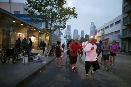 Runners from the Midnight Mission Running Club begin a sunrise run through skid row in Los Angeles, California April 20, 2015. REUTERS/Lucy Nicholson