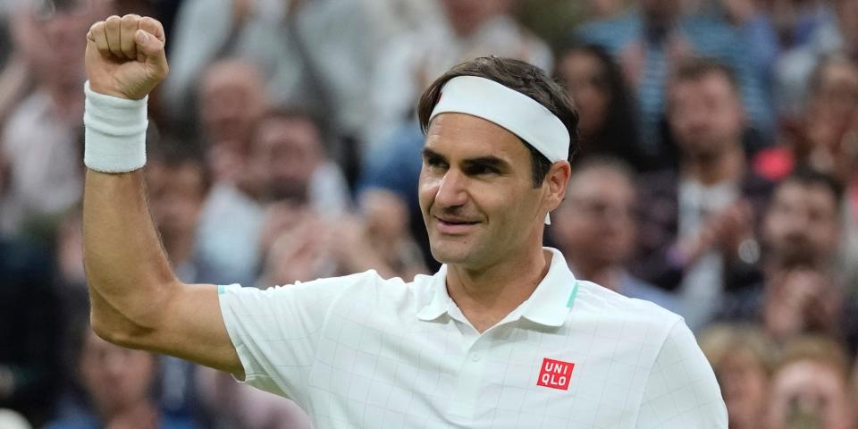 Roger Federer holds up his fist and smiles during Wimbledon in 2021.