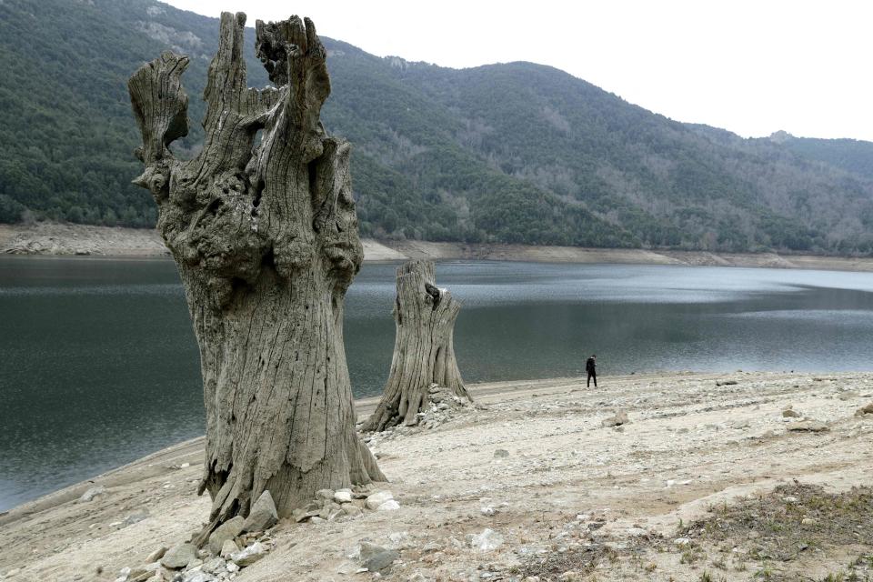 A teenager walks along the shrunken Tolla lake due to drought, on the French Mediterranean Island of Corsica, on February 24, 2023.