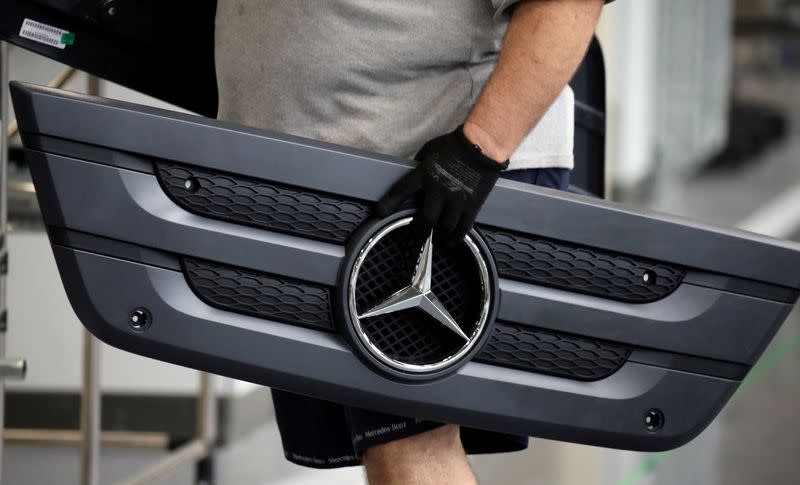 FILE PHOTO: An employee carries a component of a truck at Mercedes Benz's trucks and buses manufacturing plant in Sao Bernardo do Campo