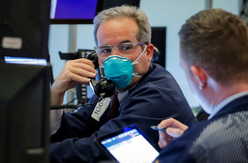 FILE PHOTO: A trader wears a face mask on the floor of the NYSE in New York