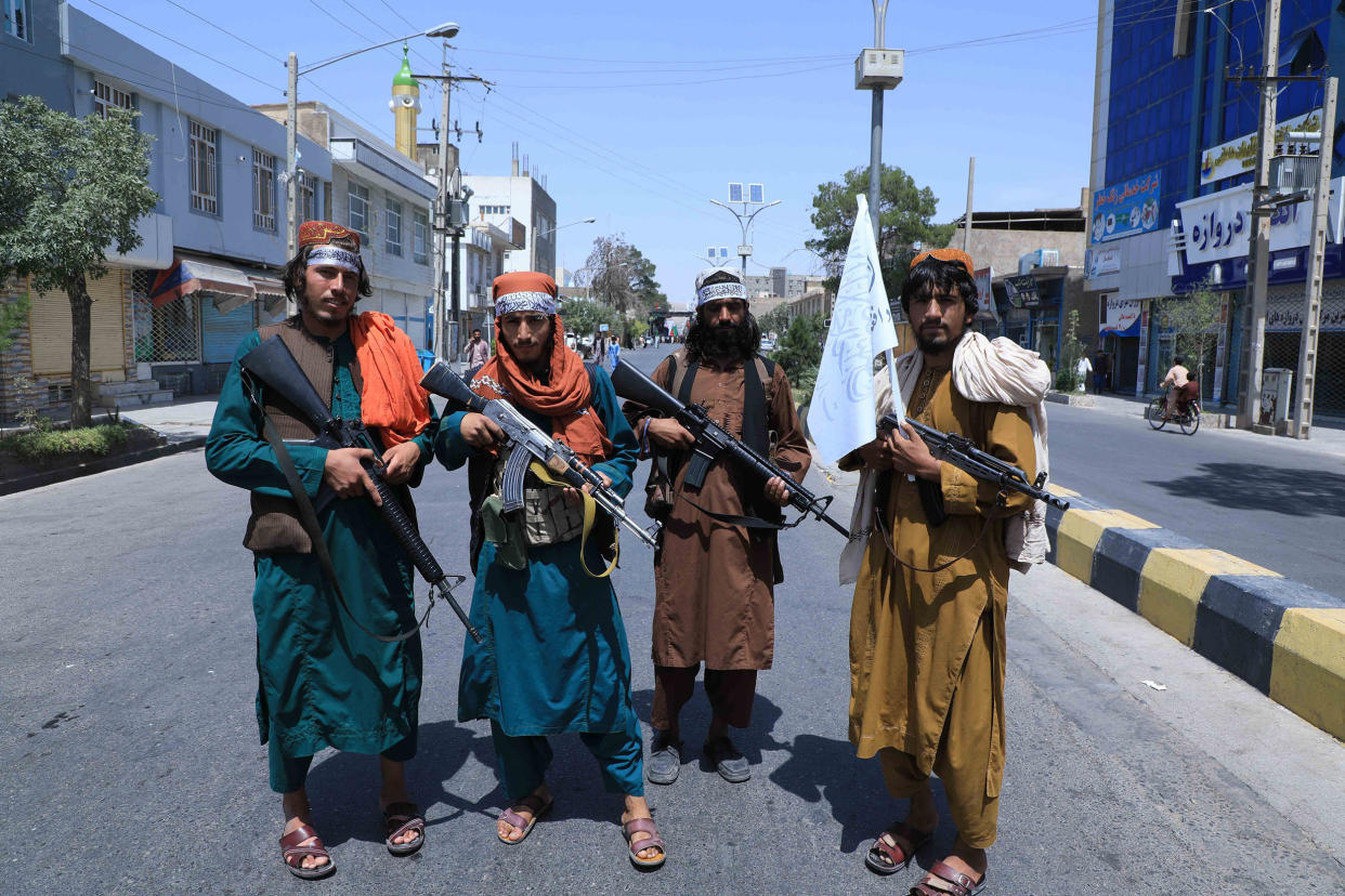 Image: Taliban fighters stand guard along a road near the site of an Ashura procession in Herat (Aref Karimi / AFP - Getty Images)