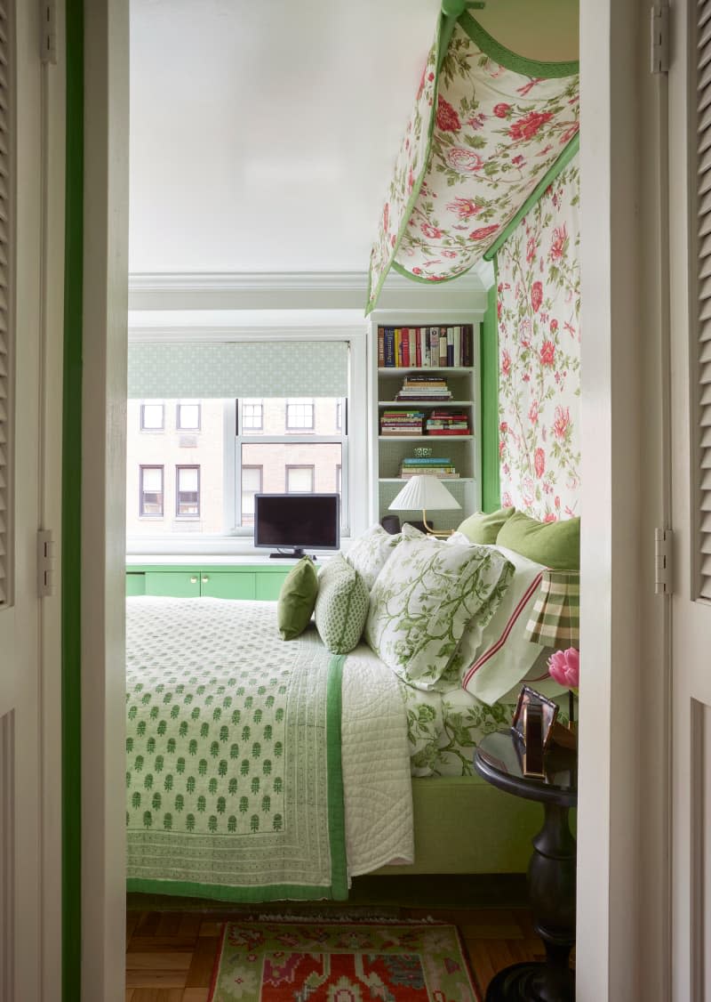 View into green bedroom with floral canopy over bed.