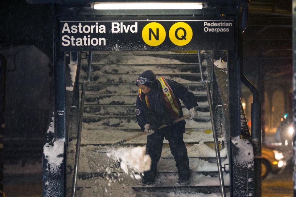 A worker clears snow from a stairway at the Astoria Blvd subway station, Friday, Jan. 3, 2014, in the Queens borough of New York. New York City public schools were closed Friday after up to 7 inches of snow fell by morning in the first snowstorm of the winter. (AP Photo/John Minchillo)