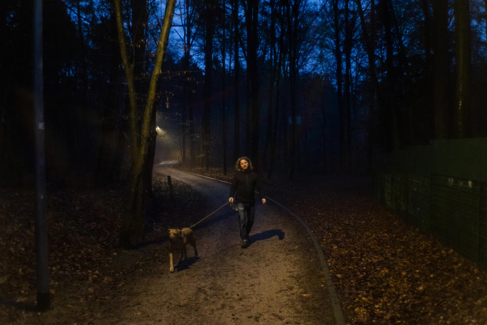 Man walking dog at night