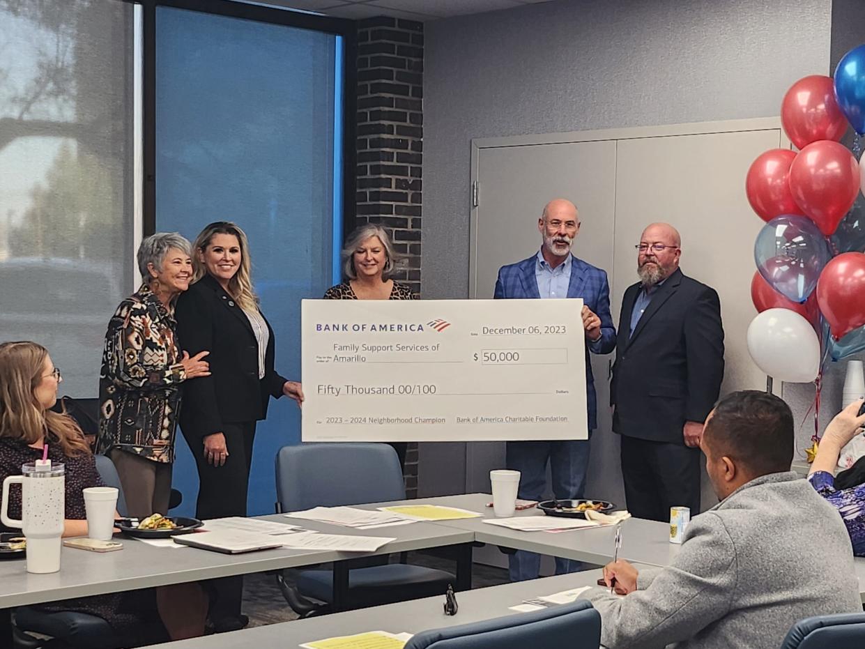 Family Support Services CEO Jim Womack (right) accepts a $50,000 grant from Bank of America representatives during Wednesday's board meeting held in the FSS, conference room, located at 2209 SW 7th Ave.