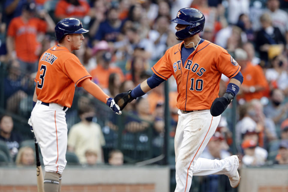 Houston Astros' Myles Straw (3) and Yuli Gurriel (10) celebrate after Gurriel scored on a single by Kyle Tucker during the second inning of a baseball game against the Texas Rangers on Friday, May 14, 2021, in Houston. (AP Photo/Michael Wyke)