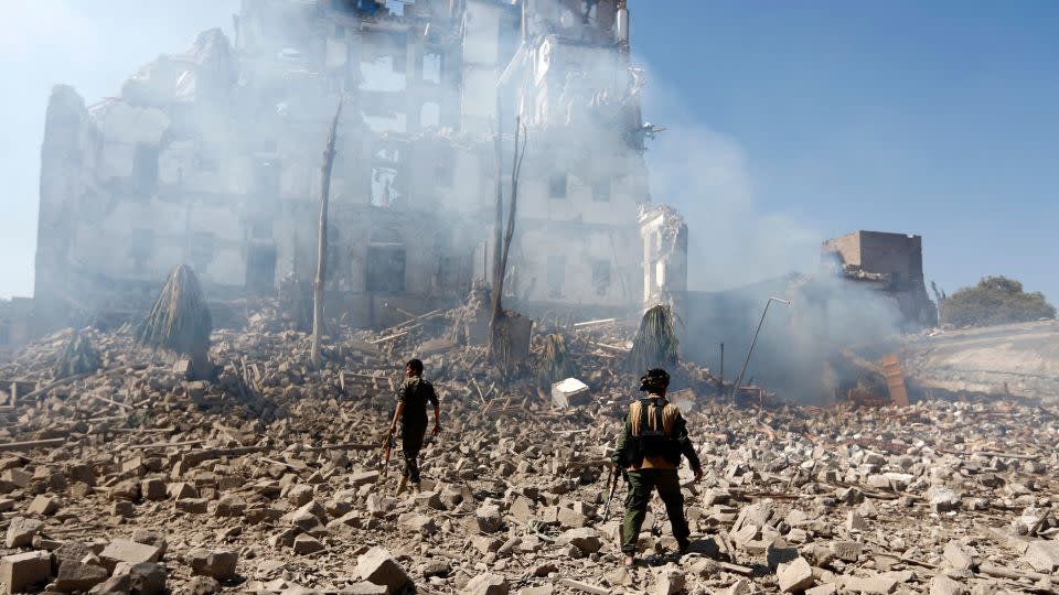 Years of civil war has ravaged parts of Yemen, against the backdrop of a wider conflict between Houthi rebels and the Saudi-led coalition. In this image from December 5, 2017, Houthi fighters inspect the damage after a reported air strike carried out by Saudi-led forces on the presidential palace in the capital Sanaa. - Mohammed Huwais/AFP via Getty Images