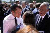French President Emmanuel Macron kisses a well-wisher while taking a walk with his Portuguese counterpart Marcelo Rebelo de Sousa, right, on a walkway outside the venue hosting the United Nations Ocean Conference in Lisbon, Thursday, June 30, 2022. From June 27 to July 1, the United Nations is holding its Oceans Conference in Lisbon expecting to bring fresh momentum for efforts to find an international agreement on protecting the world's oceans. (AP Photo/Armando Franca)