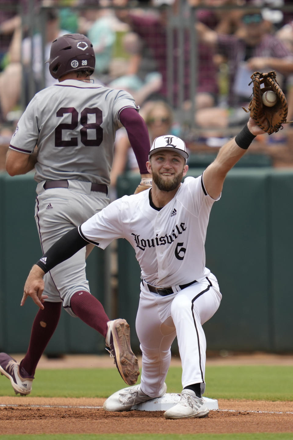 Texas A&M infielder Trevor Werner (28) beats a throw to first for a single as Louisville infielder Ben Bianco (6) catches a late throw during an NCAA college baseball super regional tournament game Saturday, June 11, 2022, in College Station, Texas. (AP Photo/Sam Craft)