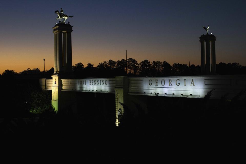 A bridge marks the entrance to the U.S. Army's Fort Benning as the sun rises in Columbus, Ga. Fort Benning is named after Confederate officers.