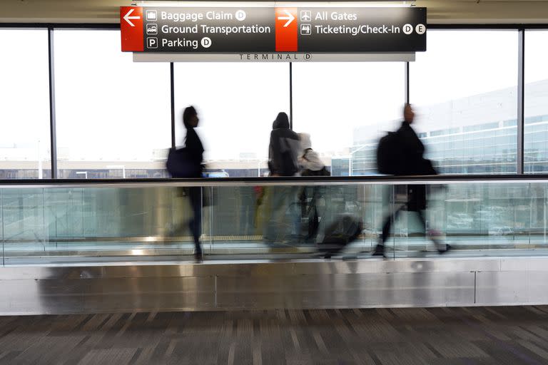 ARCHIVO - Varios viajeros avanzan por una banda transportadora el viernes 31 de diciembre de 2021, en el Aeropuerto Internacional de Filadelfia. (AP Foto/Michael Perez)