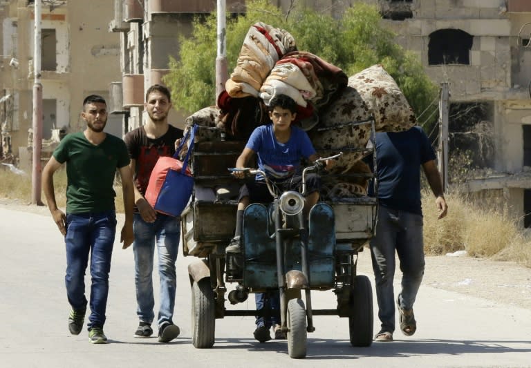 Syrian civilians originally from Daraya town are evacuated from the rebel-held town of Moadamiyet al-Sham on September 8, 2016, to be taken to a shelter in regime-held areas