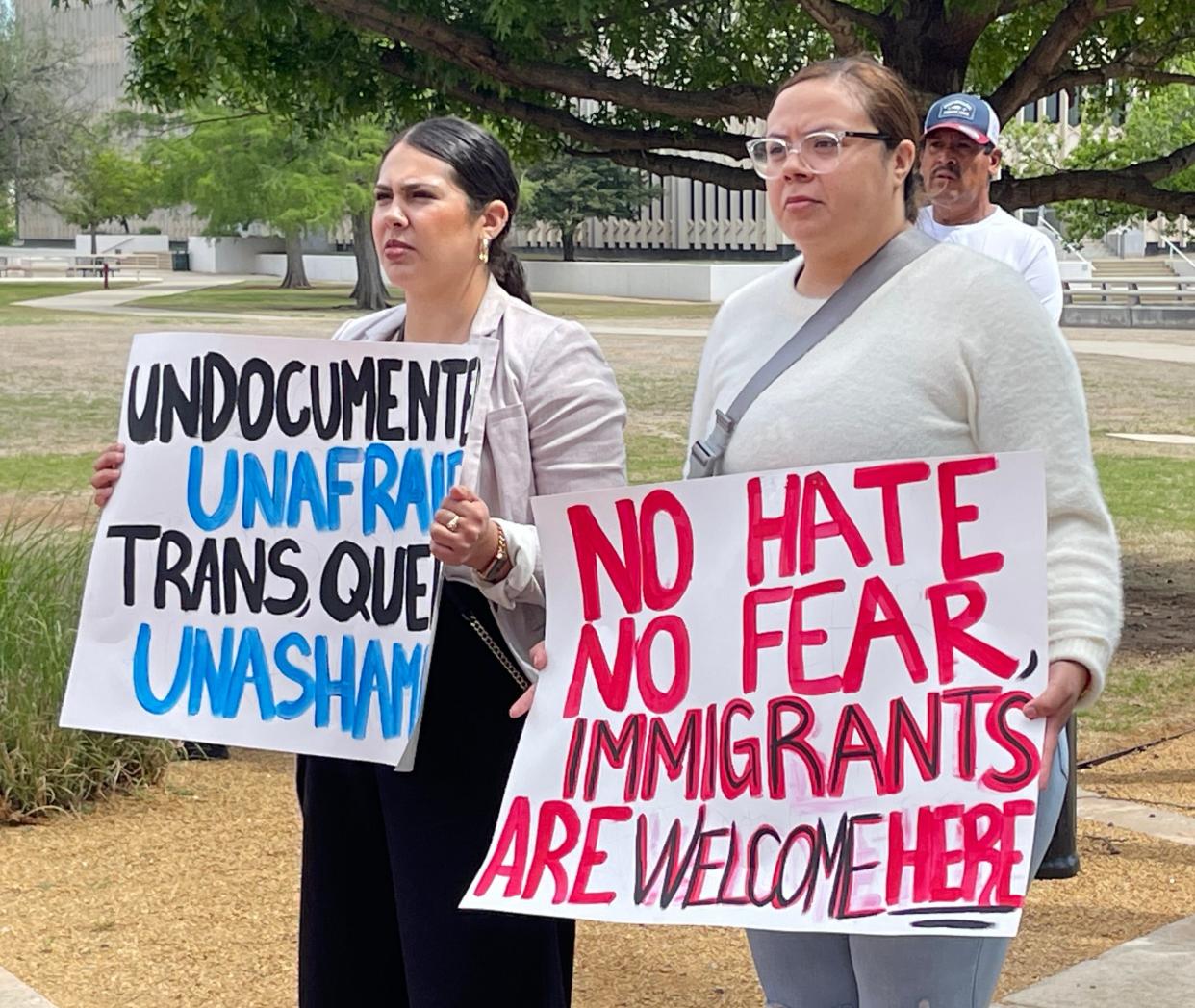 Daisy Muñoz, left, and Brenda Lozano, hold signs at the rally. Both know people who would be affected by House Bill 4156.