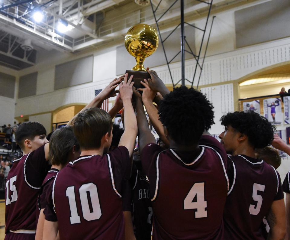 The Clarendon Broncos boys' basketball team lifts the area championship gold ball after their 86-65 win over Vega on Fridy, Feb. 25, 2022 at Canyon High School.