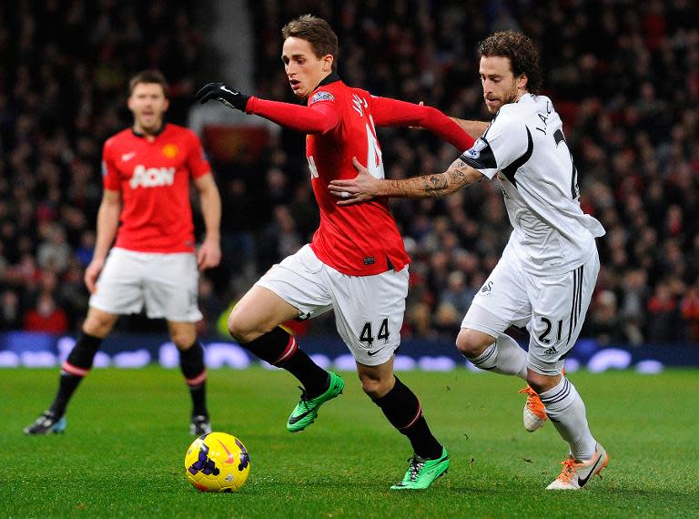 Manchester United's Adnan Januzaj (C) clashes with Swansea City's Jose Canas during their English Premier League match, at Old Trafford in Manchester, on January 11, 2014