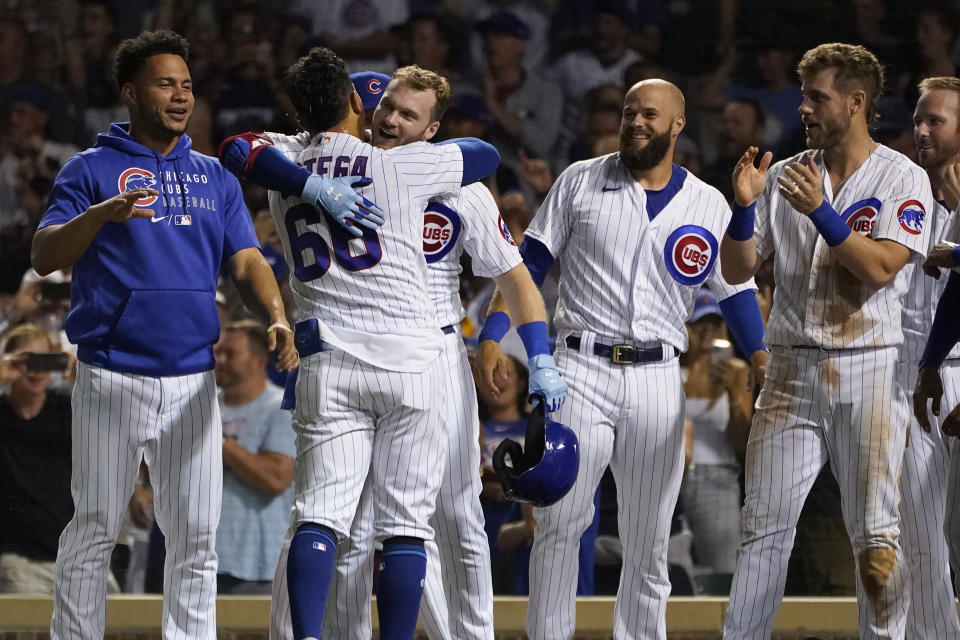 Chicago Cubs' Rafael Ortega (66) is hugged by Ian Happ after Ortega's two-run, walk off home run during the ninth inning of a baseball game against the Colorado Rockies Monday, Aug. 23, 2021, in Chicago. The Cubs won 6-4. (AP Photo/Charles Rex Arbogast)