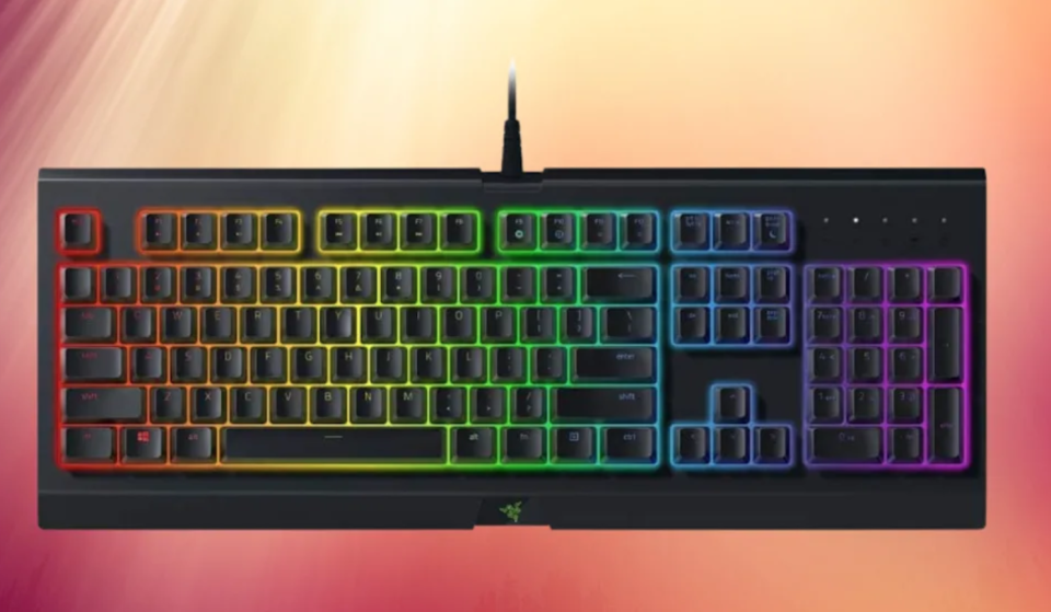 A black gaming computer keyboard with keys backlit with rainbow colors