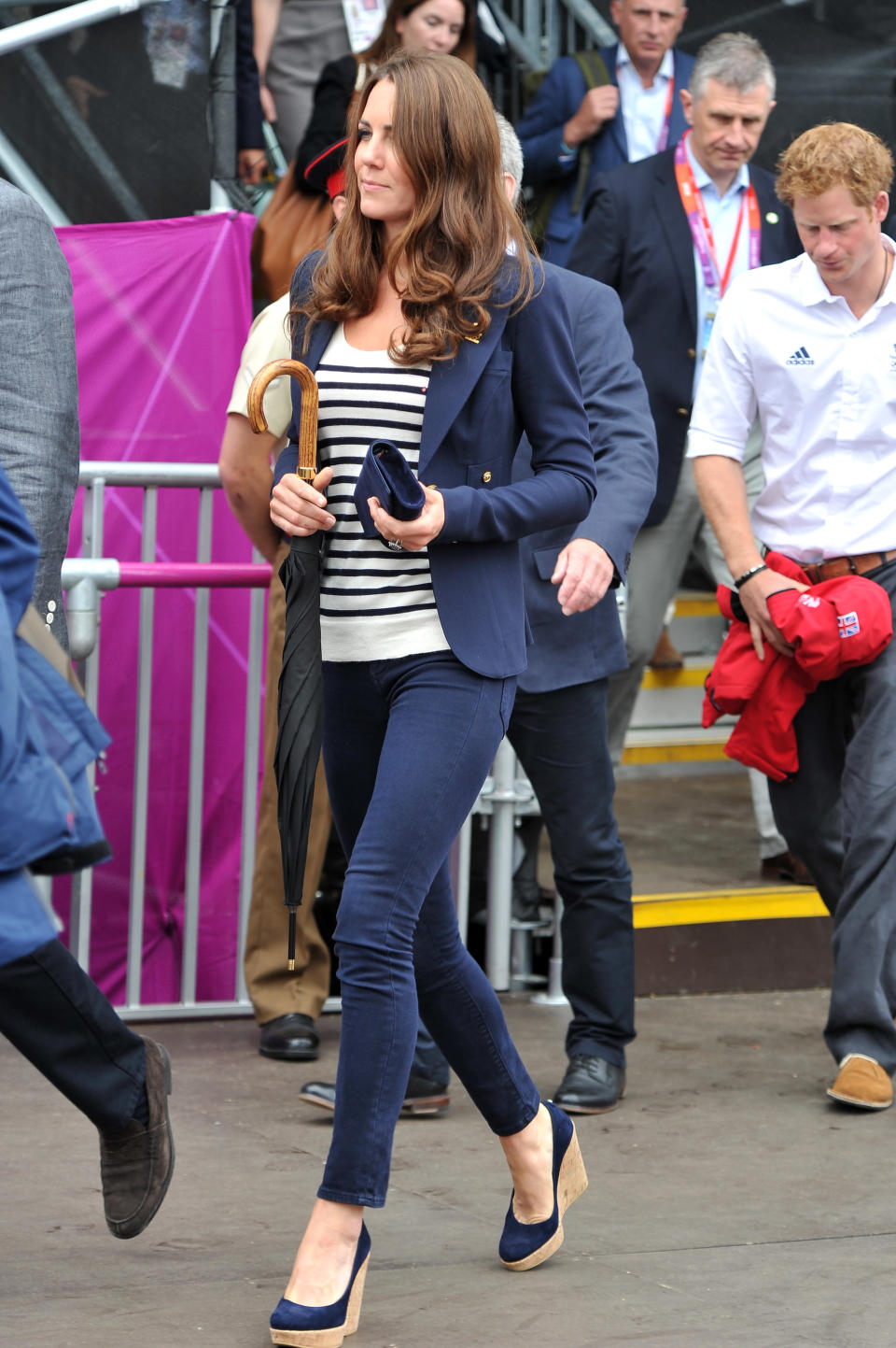 Kate’s navy blazer, pants, wedges, and clutch could easily be dull but her striped shirt pulls it together. We also can't help but notice that the umbrella is one her best unintentional accessories. <br>--<br> Catherine, Duchess of Cambridge walks to her seat prior to the Show Jumping Eventing Equestrian on Day 4 of the London 2012 Olympic Games at Greenwich Park on July 31, 2012 in London, England.