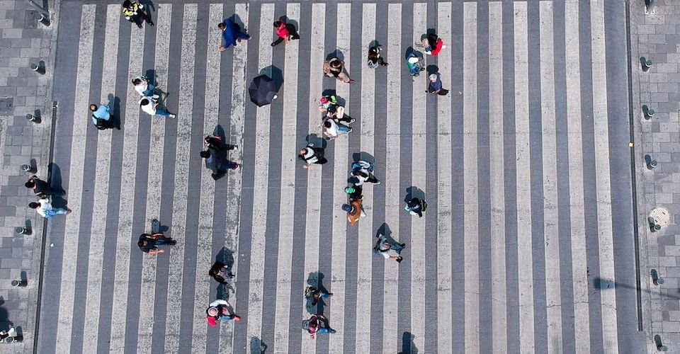 Algunas personas caminan sobre el paso peatonal en una de las avenida de la capital.