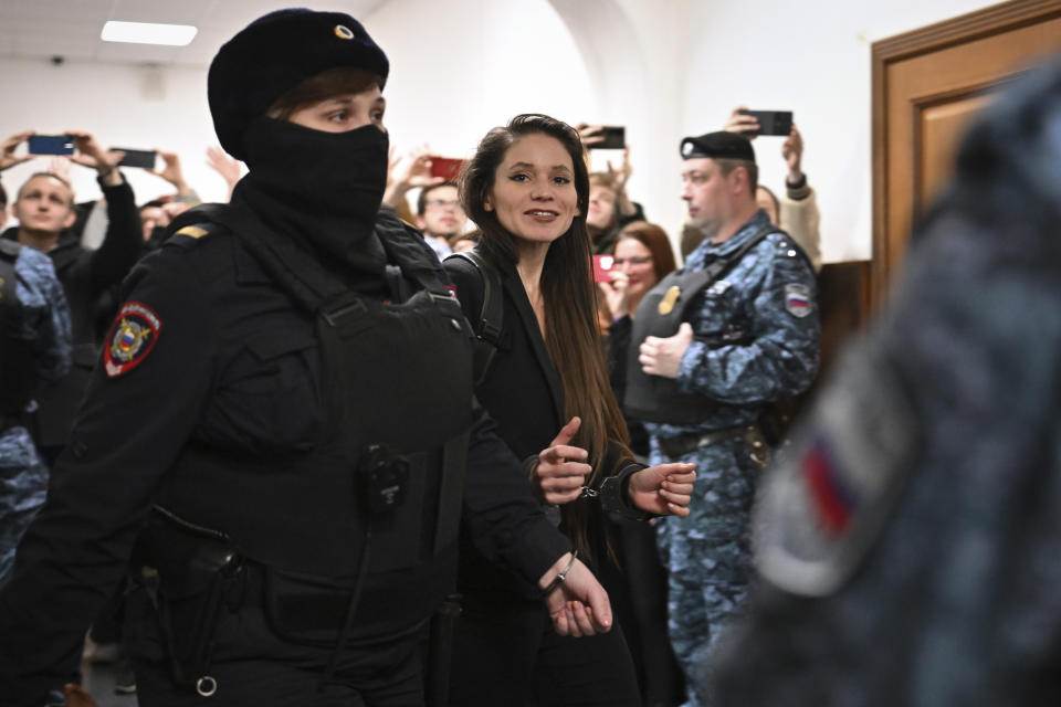 Antonina Favorskaya is escorted by a police officer to the courtroom in the Basmanny District Court in Moscow, Russia, Friday, March 29, 2024. A court in Moscow makes a decision on measure of restrain to journalist Antonina Favorskaya in the case of her connection with the FBK, the Anti-Corruption Foundation set up by Russian opposition leader Alexei Navalny in 2011 and declared extremist and closed in 2021. (AP Photo/Dmitry Serebryakov)