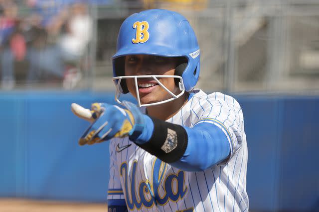 <p>Katharine Lotze/Getty</p> Maya Brady #7 of the UCLA Bruins looks on ahead of an at-bat during a game against the Stanford Cardinal at Easton Stadium on April 02, 2023 in Los Angeles, California.
